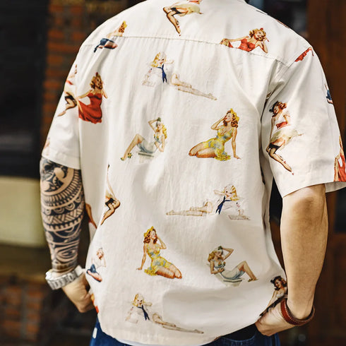 Person wearing a shirt with vintage-style pin-up girl prints.